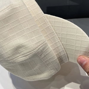Close-up of the breathable white striped fabric and stitching on a newsboy cap