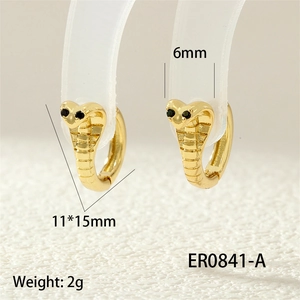 Close-up of golden cobra hoop earrings with black stone eyes and engraved details
