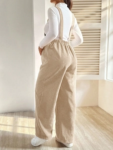 Detail of khaki corduroy maternity overalls showing side texture and elastic waist