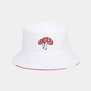 Close-up of mushroom embroidery on white canvas bucket hat with red lining detail