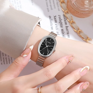 Close-up of elegant women's silver oval quartz watch with black dial and metal chain strap