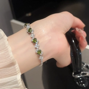 Detailed view of irregular oval green zircon stones set in silver bracelet for women