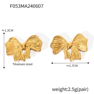 Détail de boucles d'oreilles nœud en titane avec texture côtelée et cœur