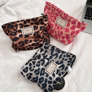 Dettaglio di pochette leopardate in marrone, grigio e rosa per trucchi e accessori