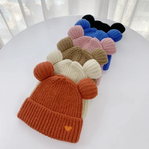 Stacked colorful bear ear knit beanies with heart labels in orange beige and blue