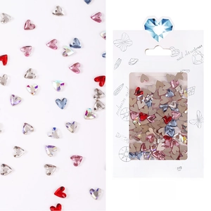 Macro shot of mixed color heart shaped crystal rhinestones for nail art in paper packaging