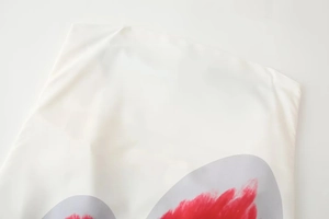 Detailed view of white polyester fabric with red and grey abstract floral print patterns