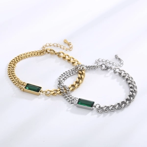 Detail of vintage gold and silver curb chain bracelets with emerald green square pendants