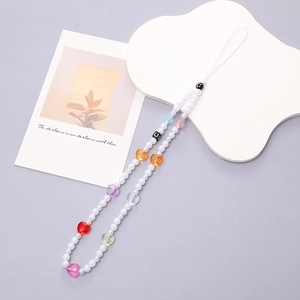 Detalle de la cadena de móvil con perlas y corazones coloridos en una bandeja nube