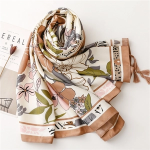 Detail of silk-feel floral scarf with elegant fringe tassels and botanical leaf pattern