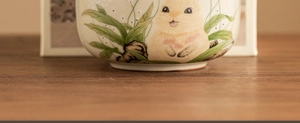 Close-up of a Ru Kiln ceramic tea canister featuring a hand-painted cute rabbit pattern