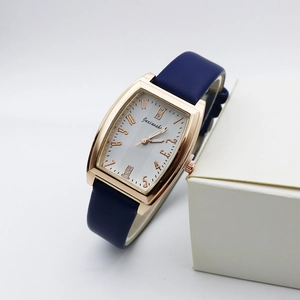 Detail of rose gold rectangular watch case with blue leather strap and crystal accents