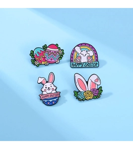 Detail of four colorful Easter enamel pins featuring rabbits and eggs on a blue surface