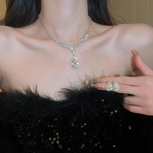 Elegant silver-toned jewelry set with teardrop crystals worn by a model in black outfit