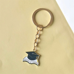 Black graduation cap and open book keychain with golden metal ring and chain
