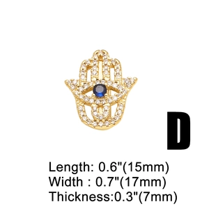 Detailed view of gold Hamsa Hand charm with blue eye and white zircon inlay details