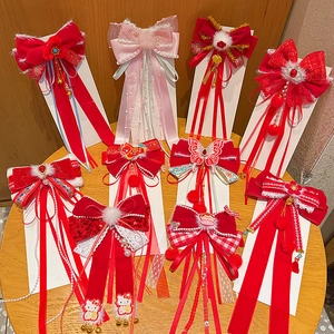 Close-up of red and pink New Year hair clips with tassels and Hello Kitty embroidery