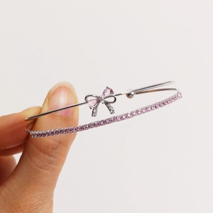 Close-up of double-layer bow bracelet with pink crystals and silver-plated finish