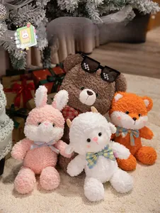Soft plush animal toys including pink rabbit and brown bear in festive Christmas setting