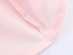 Gros plan sur un tissu en résille rose avec coutures de qualité et finitions de bordure