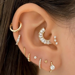 Set di orecchini e piercing per setto in oro e zirconi con pietre brillanti su modella