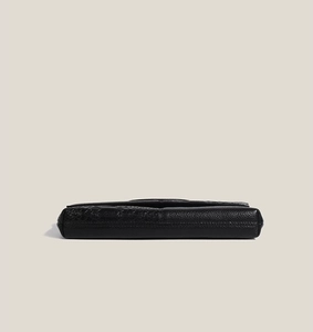 Side view of black faux crocodile leather clutch showing embossed texture and stitching