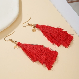 Detail of handmade red fringe earrings with gold star charms and metallic hooks