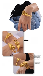 Detail view of bold gold ball terminal spring cuff bracelet on a model wrist
