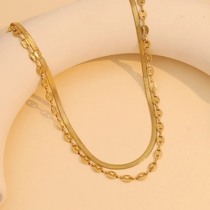 Dettaglio ravvicinato della collana dorata a due strati con catena a serpente lucida