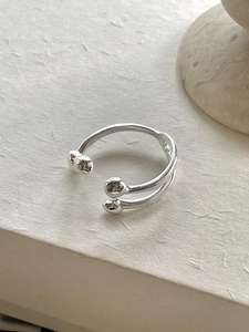Detail of minimalist 925 sterling silver double-layered open ring with ball charms