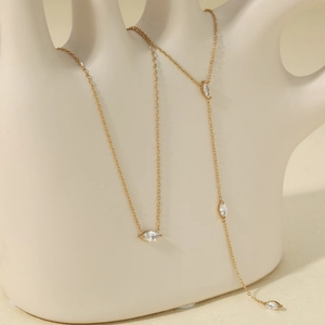Minimalist gold teardrop necklace with sparkling marquise cut stones on elegant hand sculpture