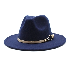 Détail du chapeau fedora bleu foncé avec ruban beige et boucle dorée chic