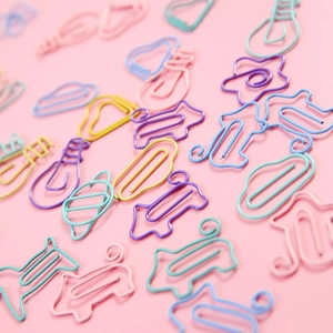 Creative colorful metal paperclips in star and cloud shapes on pink background