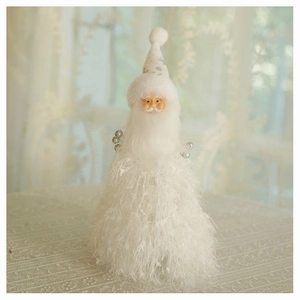 Detailed close-up of a plush Santa Claus figurine with tassel hat in a warm indoor setting