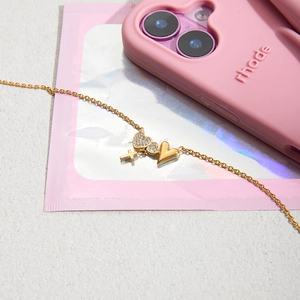 Macro view of gold double heart and cross pendant necklace with sparkling gemstones