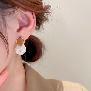 Detail of amber and marble resin drop earrings worn for a vintage French style look