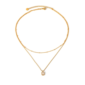 Detail of double-layer gold stainless steel necklace with a clear rectangular gemstone pendant