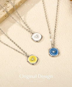 Détail de colliers en métal liquide irrégulier avec pendentifs cœur en émail de trois couleurs