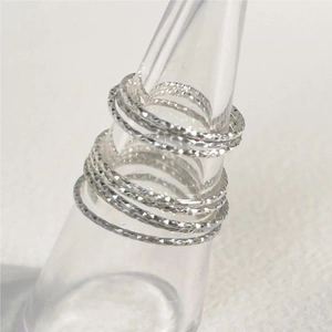S925 sterling silver thin rings with diamond-cut texture on a transparent display stand