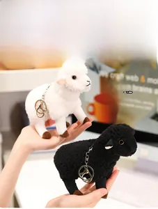 Détail de porte-clés mouton en peluche noir et blanc avec texture douce et attache métal