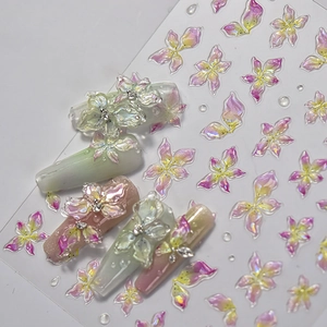 Gros plan de stickers 3D pour ongles aux motifs floraux irisés dégradés rose et jaune