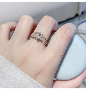 Close-up of crown stacking rings with silver and rose gold finish on a finger