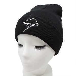 Black knitted beanie featuring white cloud and lightning embroidery on a display head