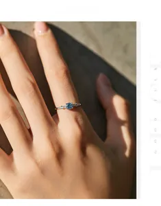 Close-up of s925 silver ring featuring a round blue gemstone and side-set diamonds