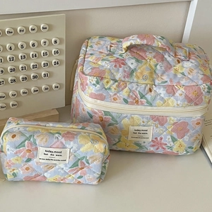 Detailed macro of floral quilted makeup bags with soft cotton texture and zipper closures