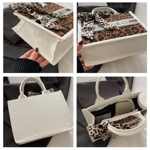 Detail view of large white tote bag with leopard print panels and interior storage space