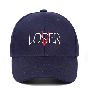 Detail of navy blue cotton baseball cap featuring white LOSER embroidery with a red V