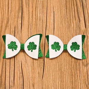Close-up of Saint Patrick's Day glitter bows with shamrock pattern on wood background