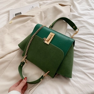 Detail of green forest green wing bag with crocodile texture and gold chain link
