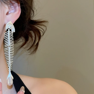 Detail of silver fishbone earrings with zircon inlay and teardrop pearl on model